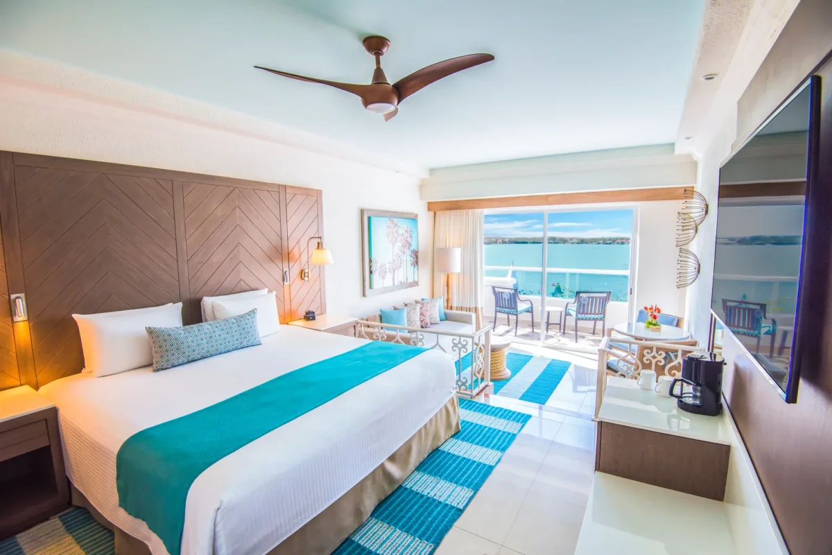 Deluxe Junior Suite king bedroom with lagoon view balcony at Sunscape Cancun Resort & Spa.