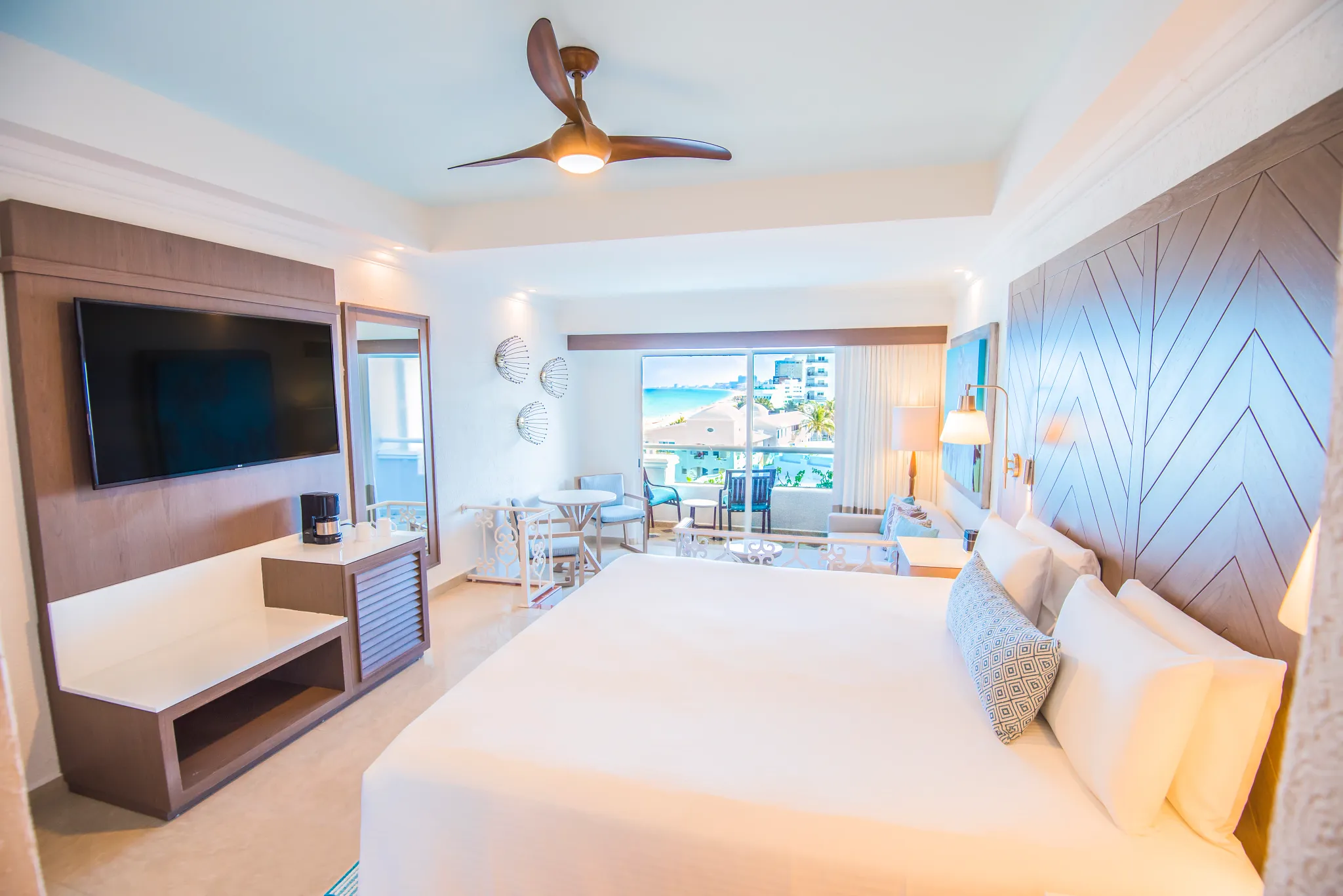 Junior Suite Ocean View with king bed and furnished balcony at Sunscape Cancun Resort & Spa.